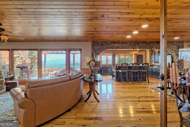 living room featuring a fireplace, wood-type flooring, a wealth of natural light, and wooden ceiling