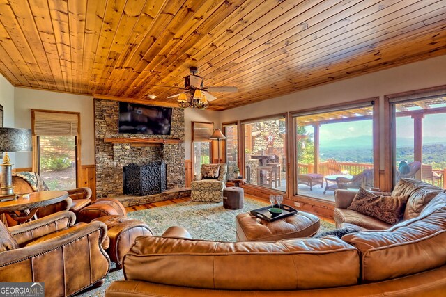 living room with a mountain view, wood-type flooring, wood ceiling, and plenty of natural light