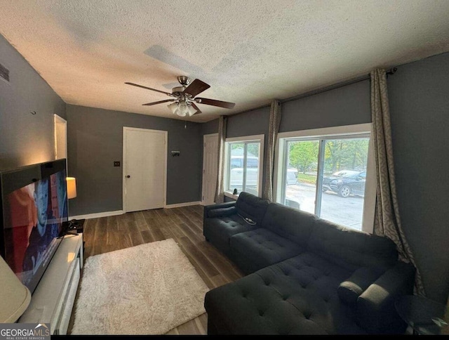 living room with hardwood / wood-style flooring, a textured ceiling, and ceiling fan