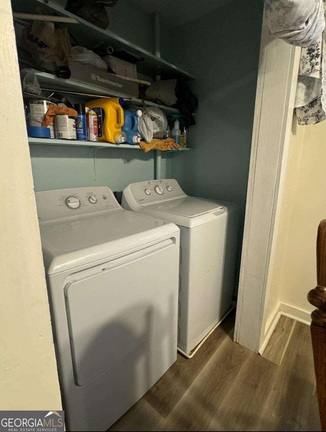 clothes washing area featuring dark wood-type flooring and washing machine and clothes dryer