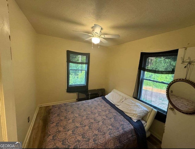 bedroom with a textured ceiling and ceiling fan