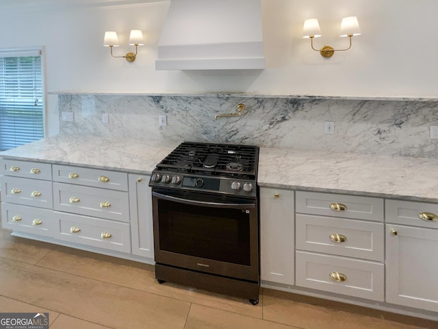 kitchen with light stone countertops, range with gas cooktop, wall chimney exhaust hood, and tasteful backsplash