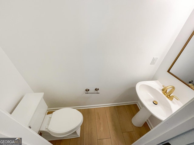 bathroom with hardwood / wood-style flooring, sink, and toilet