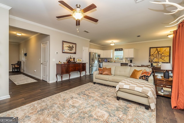 living room with crown molding, dark hardwood / wood-style floors, and ceiling fan