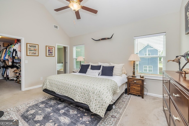 bedroom with ceiling fan, multiple windows, a spacious closet, light colored carpet, and a closet