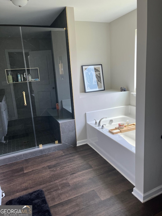 bathroom with independent shower and bath and hardwood / wood-style floors