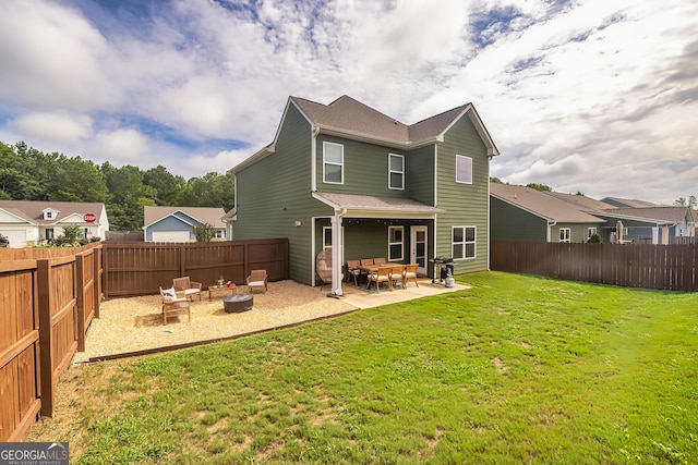 rear view of property featuring a yard, a patio area, and a fire pit