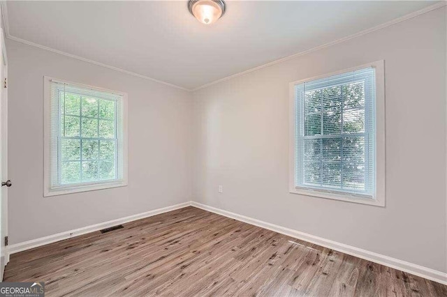 unfurnished room featuring crown molding and light hardwood / wood-style flooring