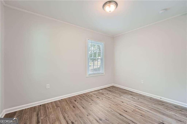 spare room featuring crown molding and light hardwood / wood-style floors