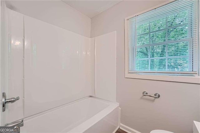 bathroom with a wealth of natural light and shower / tub combination