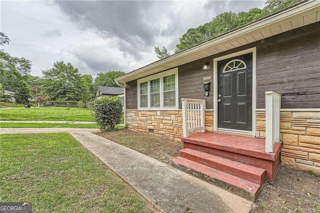 doorway to property featuring a lawn