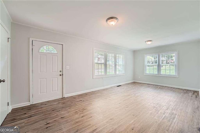 foyer entrance with crown molding and wood-type flooring