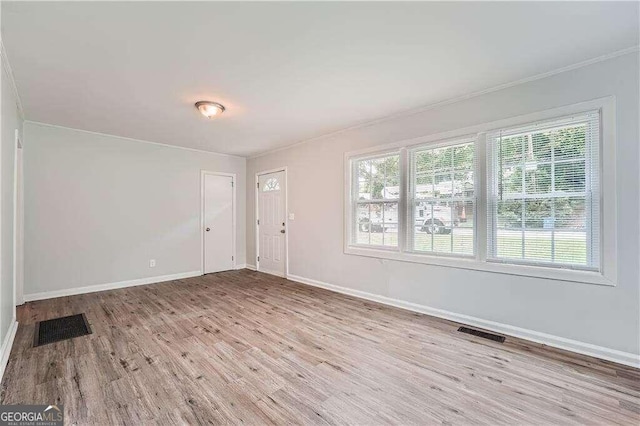 empty room featuring a healthy amount of sunlight and light hardwood / wood-style flooring