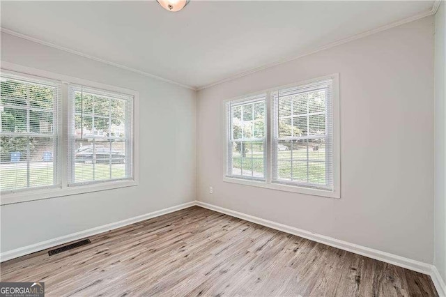 empty room featuring crown molding and light wood-type flooring