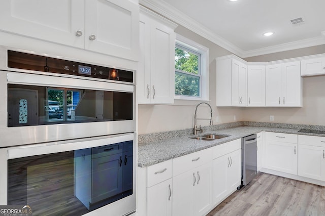 kitchen with white cabinets, sink, light stone counters, light hardwood / wood-style flooring, and crown molding