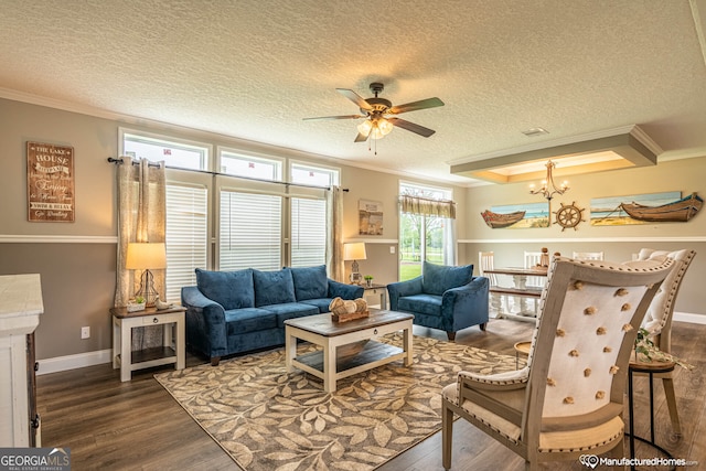 living room featuring ceiling fan with notable chandelier, a textured ceiling, ornamental molding, and dark hardwood / wood-style floors