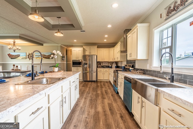 kitchen featuring decorative light fixtures, appliances with stainless steel finishes, a tray ceiling, dark wood-type flooring, and ornamental molding