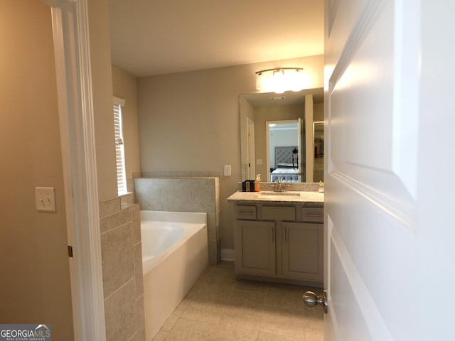 bathroom featuring vanity, a tub to relax in, and tile patterned floors