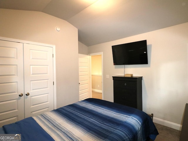 bedroom with carpet floors, a closet, and lofted ceiling