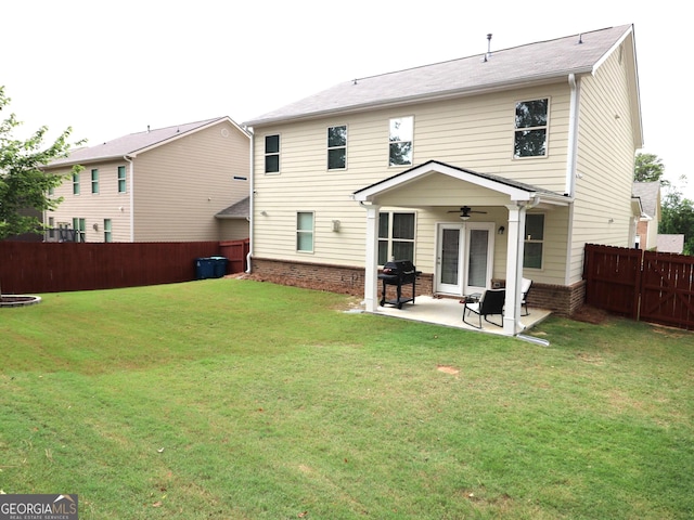 back of property with a patio area, a yard, and ceiling fan