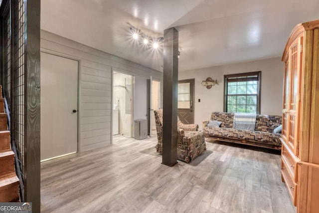 living room with wood walls and light hardwood / wood-style flooring