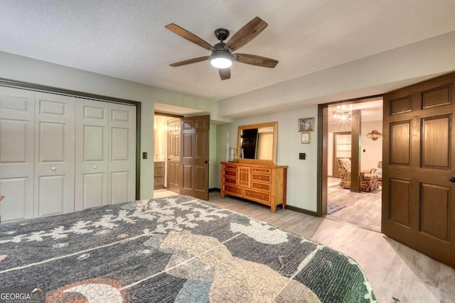 bedroom with ensuite bath, ceiling fan, a textured ceiling, light hardwood / wood-style floors, and a closet