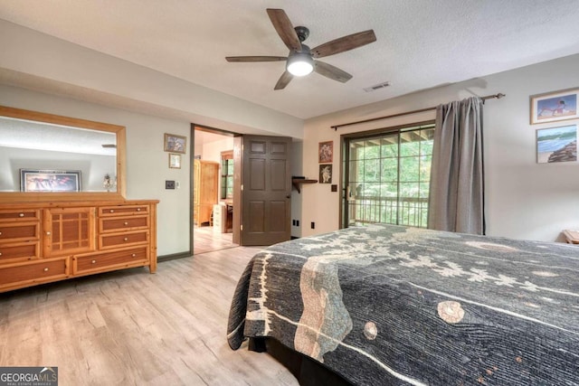 bedroom featuring ceiling fan, light hardwood / wood-style floors, access to exterior, and a textured ceiling