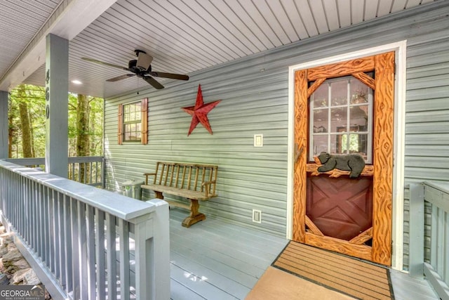 wooden terrace featuring covered porch and ceiling fan