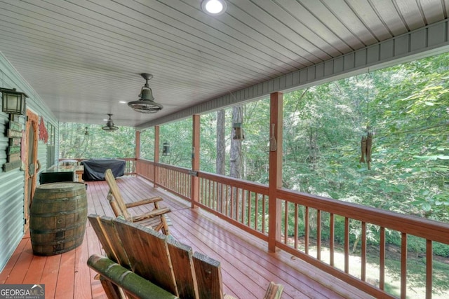 wooden terrace featuring a grill, ceiling fan, and covered porch