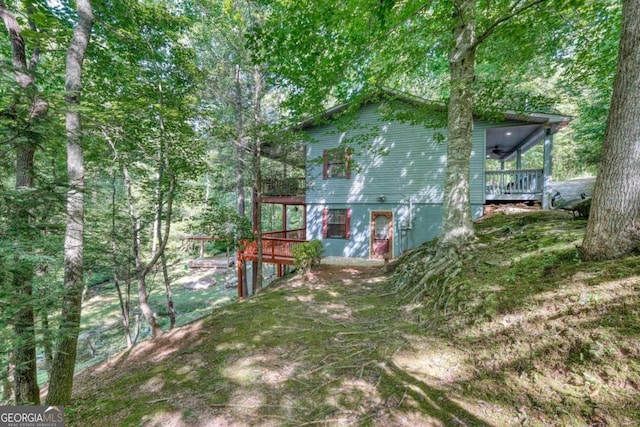 view of yard featuring ceiling fan and a deck