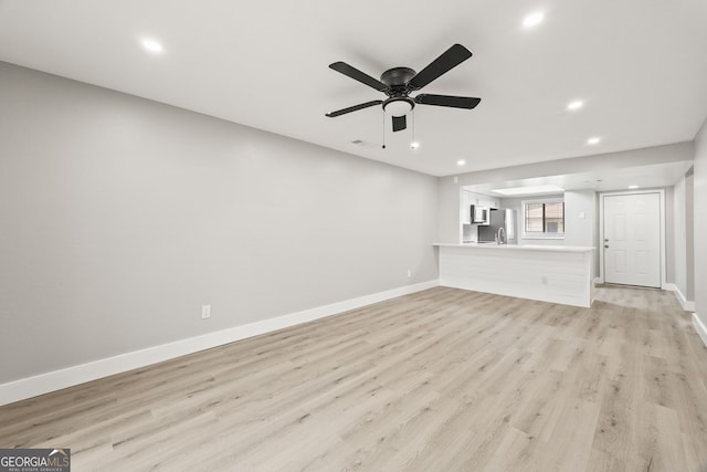 unfurnished living room with light hardwood / wood-style flooring and ceiling fan