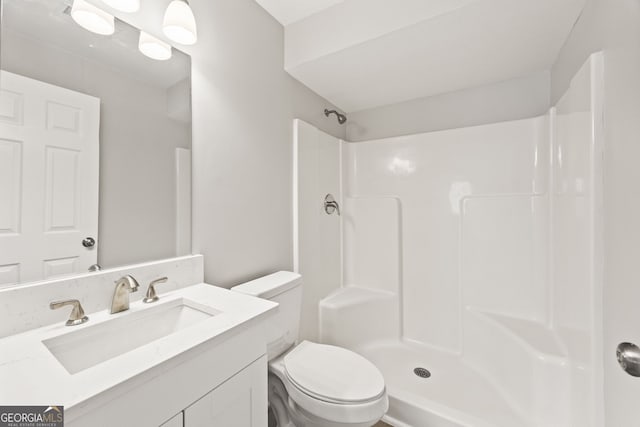 bathroom with vanity, toilet, and a shower