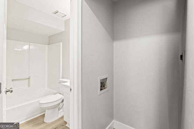 full bathroom featuring vanity, hardwood / wood-style flooring, bathtub / shower combination, and toilet