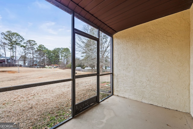 unfurnished sunroom featuring vaulted ceiling