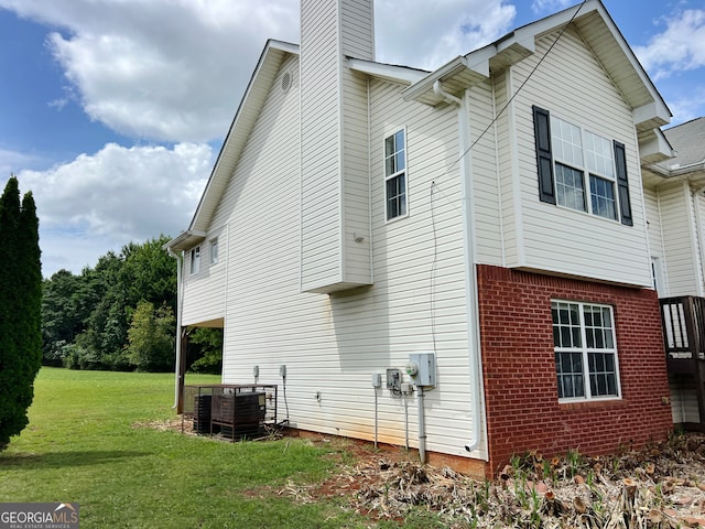 view of home's exterior featuring central air condition unit and a yard