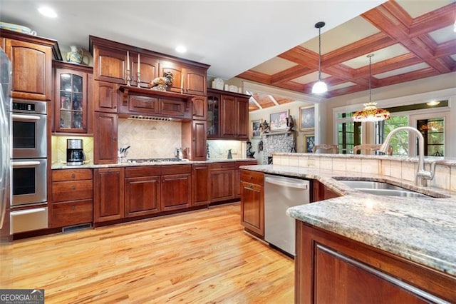 kitchen with tasteful backsplash, stainless steel appliances, sink, coffered ceiling, and light hardwood / wood-style floors