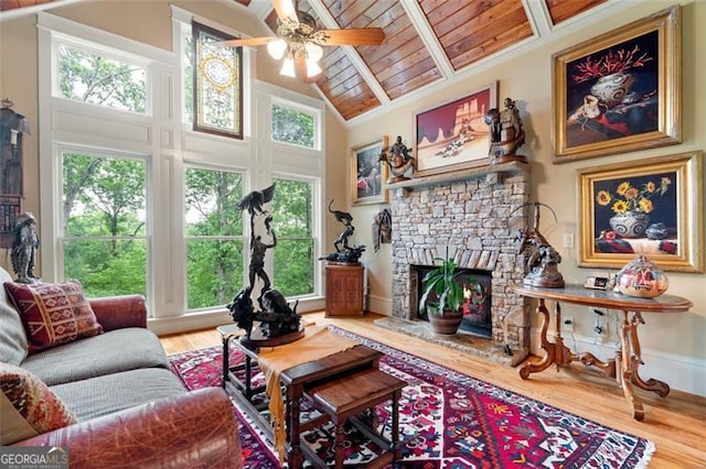 living room with a stone fireplace, hardwood / wood-style flooring, and a healthy amount of sunlight