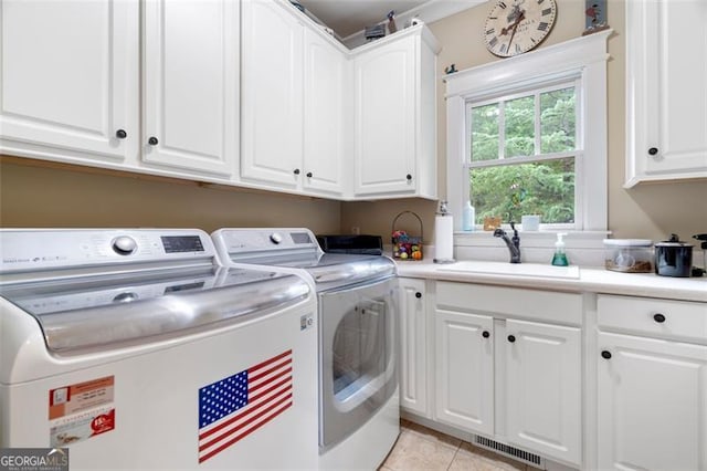 laundry room with light tile patterned flooring, sink, cabinets, and independent washer and dryer