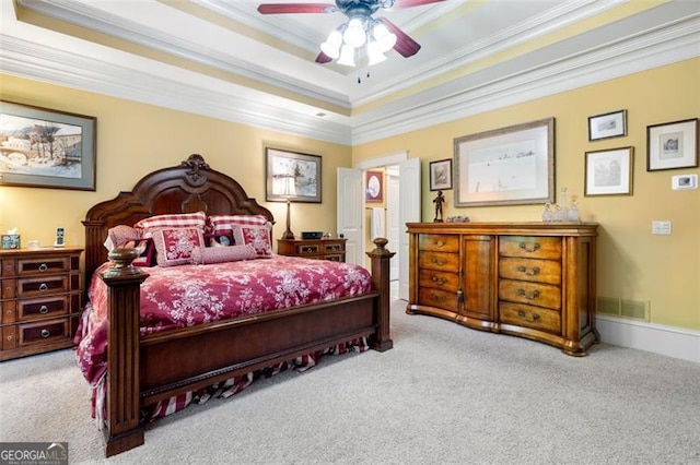 carpeted bedroom featuring crown molding, a raised ceiling, and ceiling fan