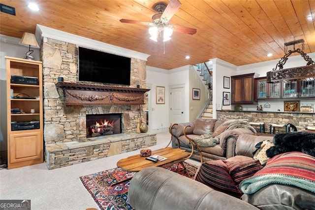 living room featuring carpet flooring, crown molding, wood ceiling, ceiling fan, and a fireplace