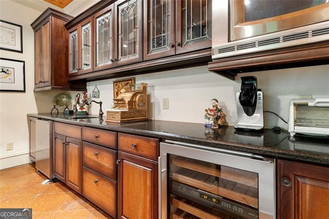 kitchen with dark stone countertops, light tile patterned floors, and wine cooler