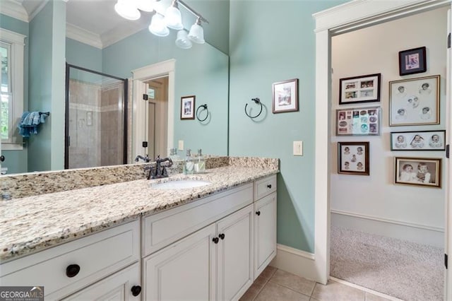 bathroom with walk in shower, tile patterned floors, crown molding, and vanity