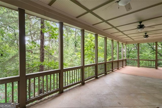 unfurnished sunroom with a healthy amount of sunlight and ceiling fan