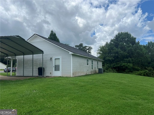 view of side of property featuring a carport, central AC, and a lawn