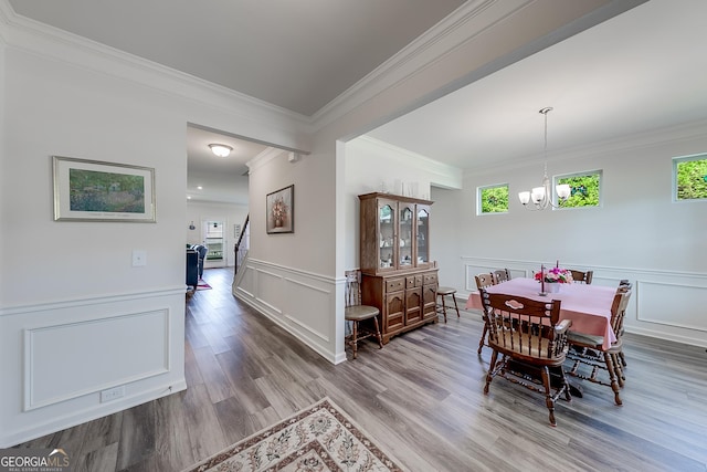 dining space with an inviting chandelier, crown molding, and hardwood / wood-style flooring