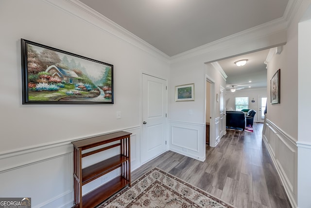 corridor featuring ornamental molding and light hardwood / wood-style floors