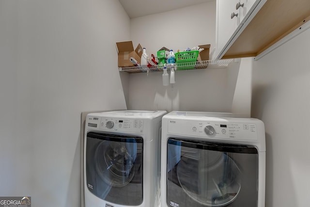 clothes washing area featuring cabinets and independent washer and dryer