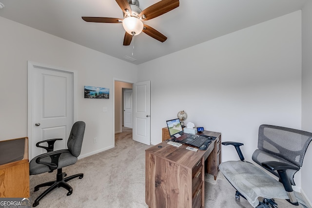 carpeted home office featuring ceiling fan