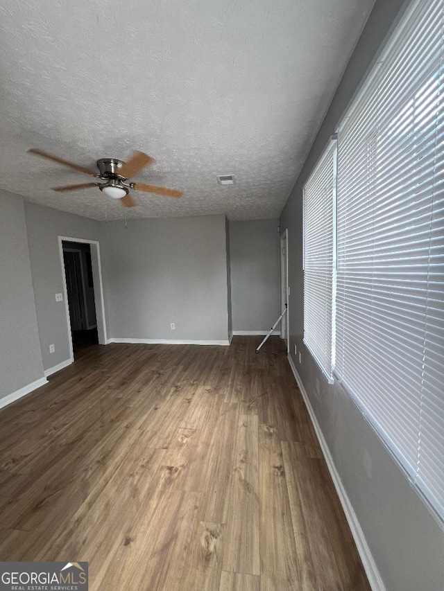 interior space with a textured ceiling, ceiling fan, and hardwood / wood-style floors