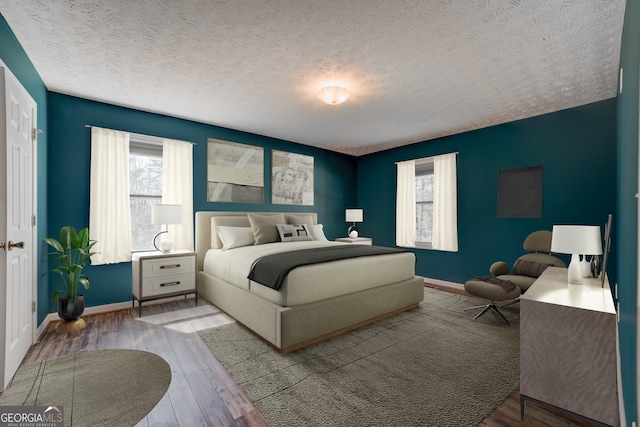 bedroom featuring wood finished floors, baseboards, and a textured ceiling